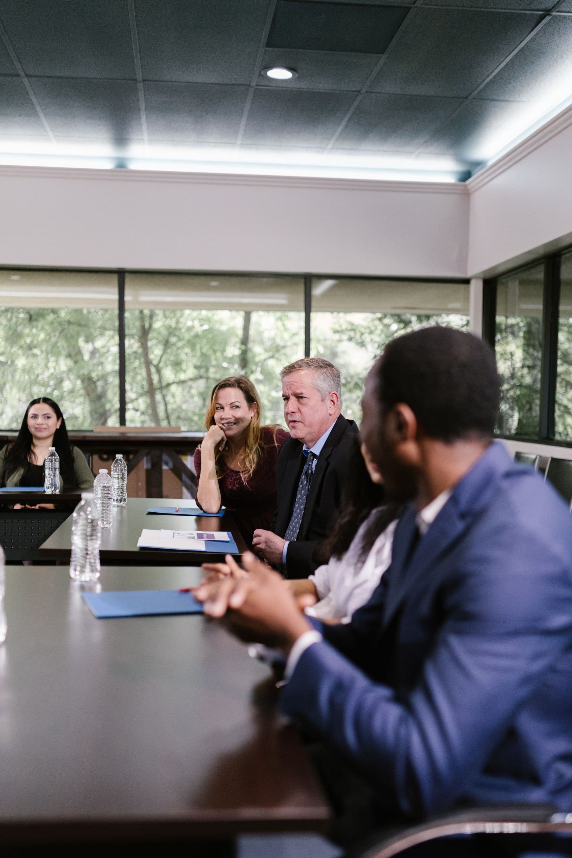 Illustrative stock photograph of professionals discussing documents around a conference table